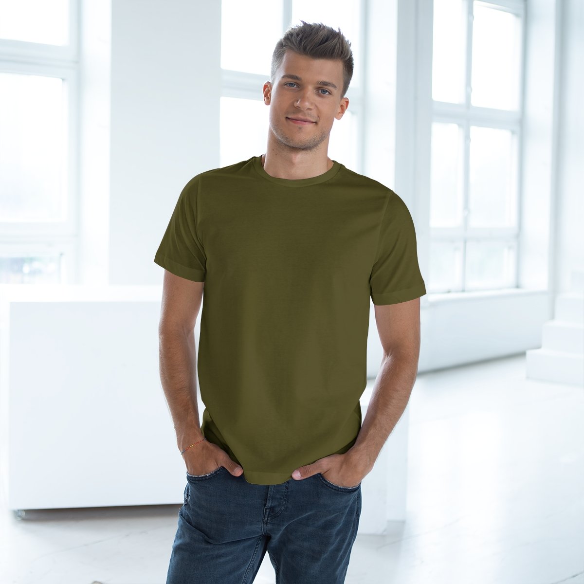 Confident man modeling an army green Eternal Zones workout shirt from Men's Gear Collection